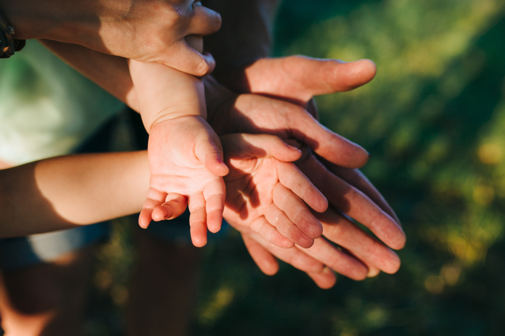 Photo des mains réunies d'une famille avec des enfants en bas âge